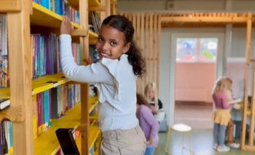 En ung barn som står i et bibliotek