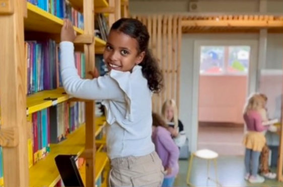 En ung barn som står i et bibliotek
