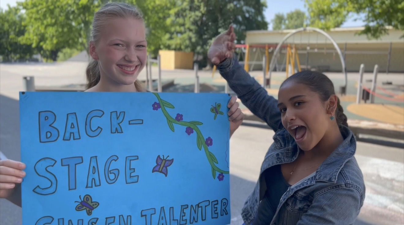 Et par barnr som holder et skilt