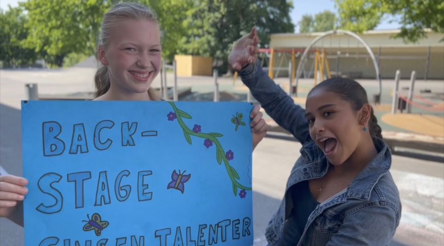 Et par barnr som holder et skilt