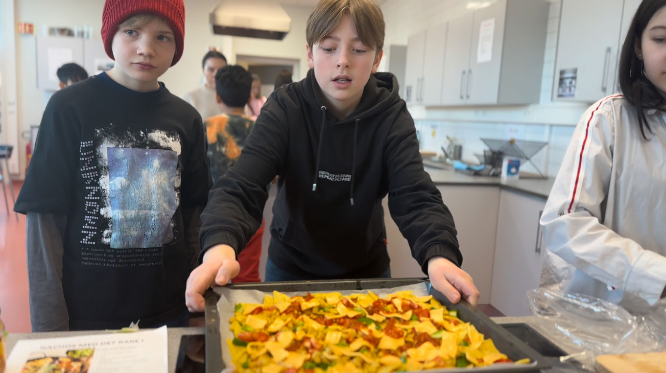 en gruppe mennesker som står rundt et bord med mat på